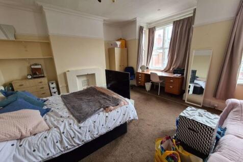 A spacious master bedroom featuring a comfortab...