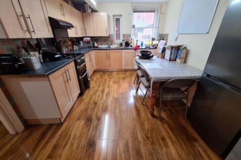 A modern kitchen featuring light wood cabinetry...