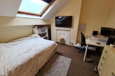 Cozy single bedroom featuring a comfortable bed...