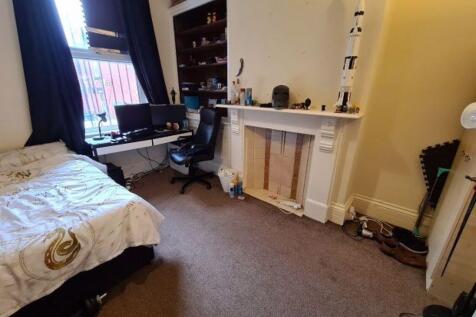 A cozy single bedroom featuring a comfortable b...