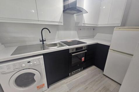 Modern kitchen with sleek black and white cabin...
