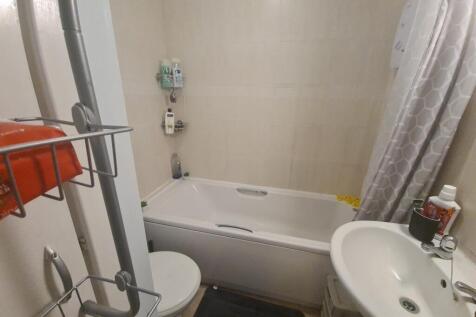 Compact, well-kept bathroom with a white bathtu...
