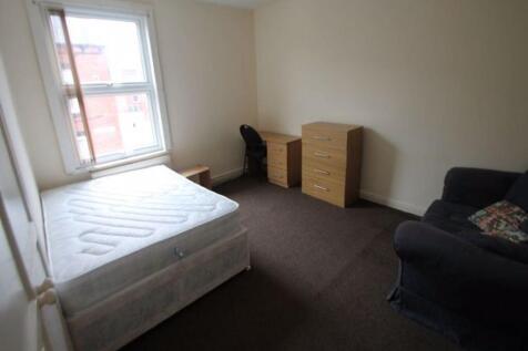 Bright master bedroom featuring a large window ...