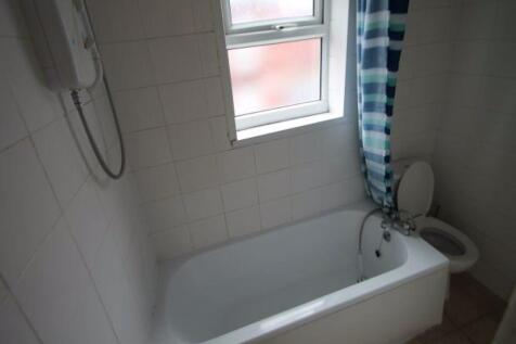 A bright bathroom suite featuring a white batht...