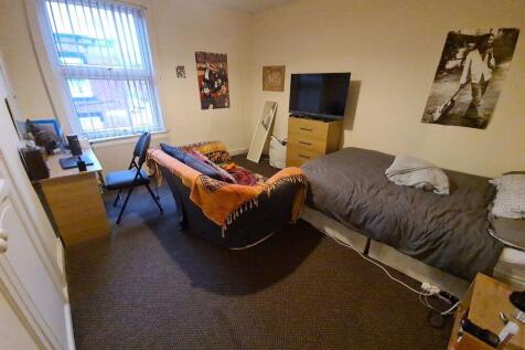 A cozy student bedroom featuring a single bed a...