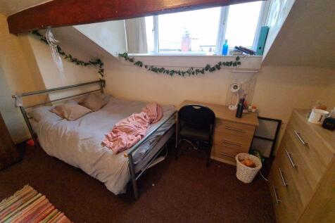 Cozy single bedroom featuring a comfortable bed...