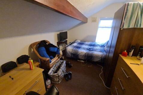 Cozy single bedroom featuring a comfortable bed...