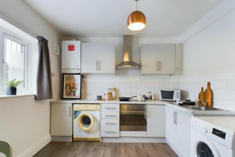 A bright and modern kitchenette with ample stor...