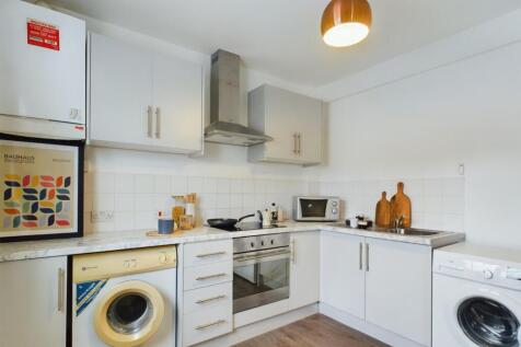 A modern and tidy kitchenette equipped with ess...