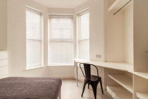 Bright bedroom with a large bay window providin...