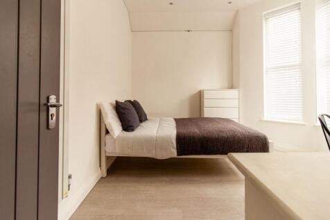 Bright, neatly styled bedroom with a comfortabl...