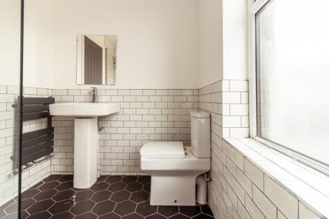 Bright, modern bathroom with geometric black fl...