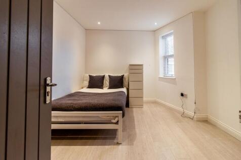 Bright, minimalist bedroom with a comfortable d...