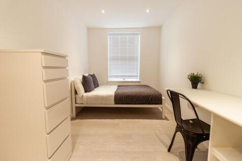 Bright, modern double bedroom with a neatly mad...