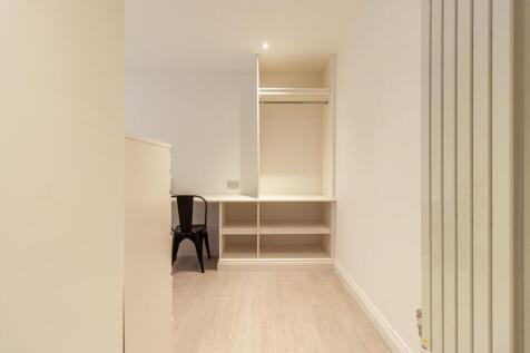 Neat, neutral single bedroom with built-in shel...