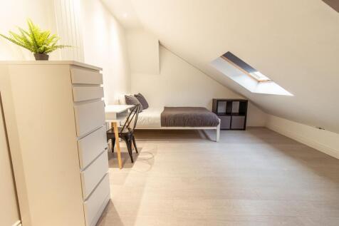 Bright, modern attic bedroom with a comfortable...