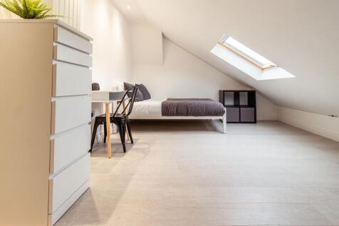 Bright, modern attic bedroom with a skylight, m...