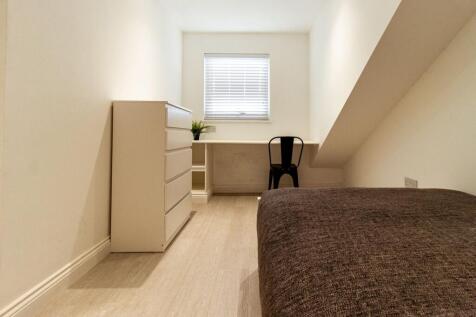 Simple, tidy single bedroom with a built-in des...