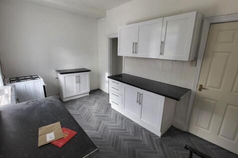 Bright fitted kitchen with white wall cabinets,...