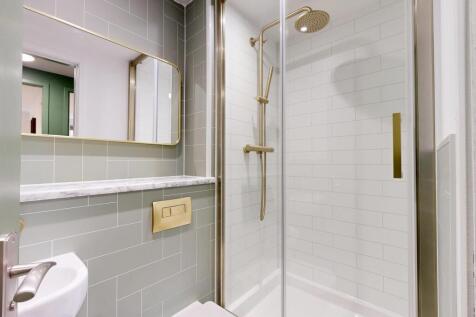 Modern bathroom with a glass-enclosed shower, b...