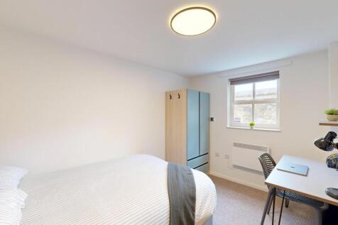 Bright, simply furnished bedroom with a comfort...