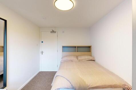 Bright, simply furnished bedroom with a comfort...