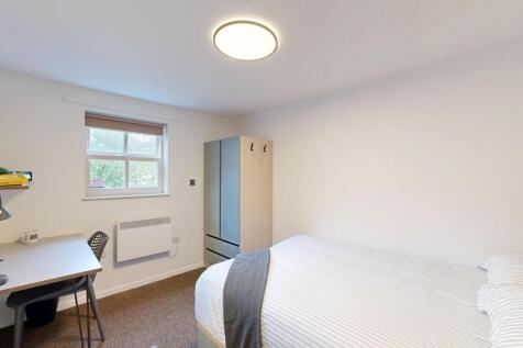 Bright, simply furnished bedroom with a comfort...
