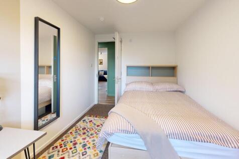 Bright, simply furnished bedroom with a comfort...