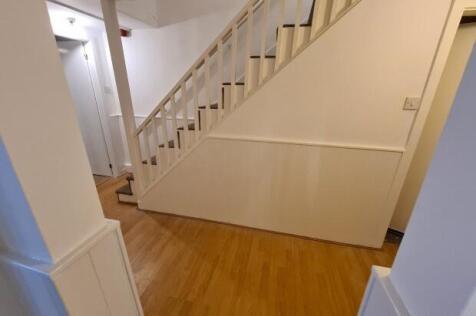 Bright, clean hallway with wooden flooring and ...