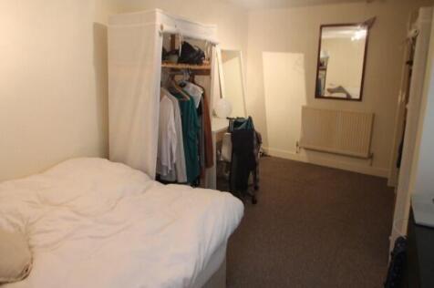 Neat, simply furnished double bedroom with a co...