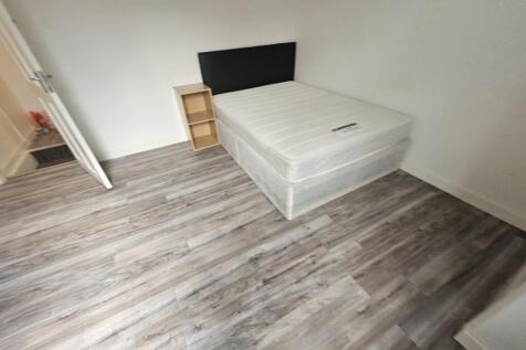 A spacious master bedroom featuring a large bed...