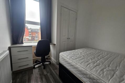 A bright and tidy student bedroom featuring a s...