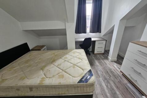 A bright and tidy bedroom featuring a double be...