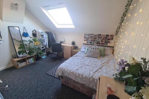 A cozy and well-lit bedroom featuring a double ...