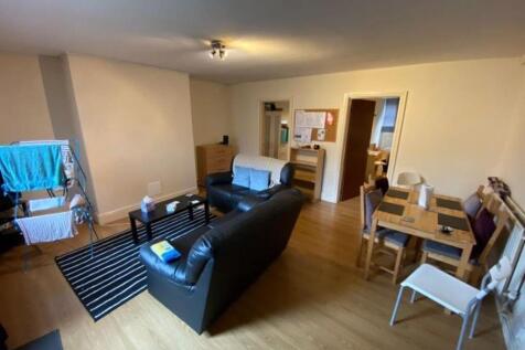 A cozy living room featuring wooden flooring, a...