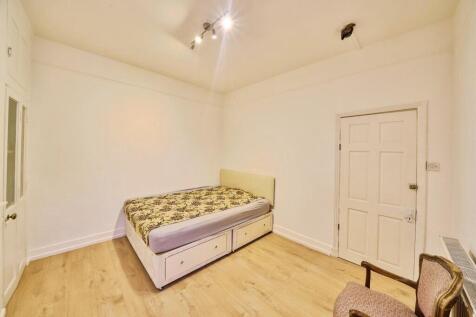 Bright, simply furnished bedroom with a double ...