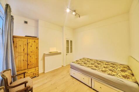 Bright, simply furnished bedroom with wood-effe...