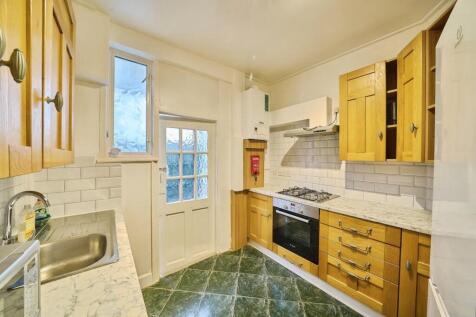 Bright, well-kept kitchen with wooden cabinetry...