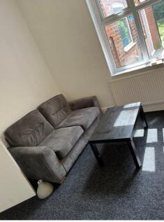 A cozy living room featuring a comfortable grey...