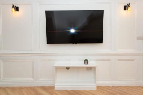 Stylish living area with a wall-mounted flat-sc...