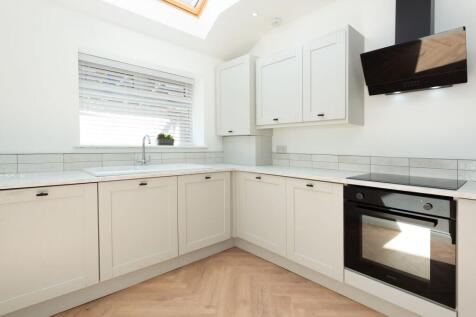 Bright, modern fitted kitchen with light cabine...