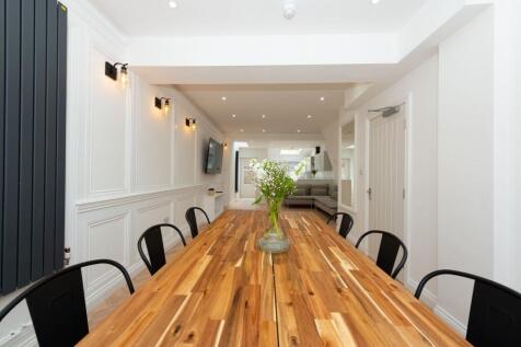 Bright, modern communal lounge with a long wood...