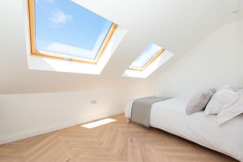 Bright attic bedroom with two large skylights f...