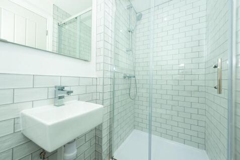 Bright, modern bathroom with a tiled walk-in sh...