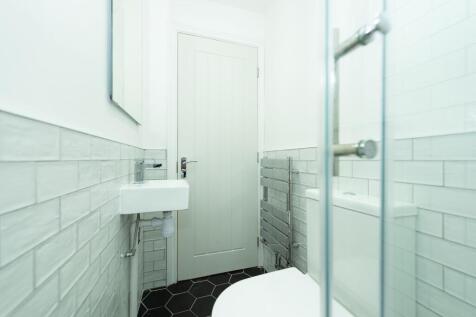Modern compact bathroom with white subway tiles...