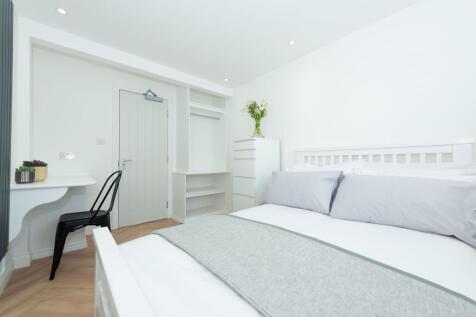 Bright, modern double bedroom with clean white ...