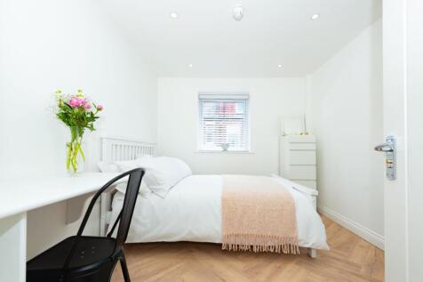 Bright, neatly styled double bedroom with fresh...