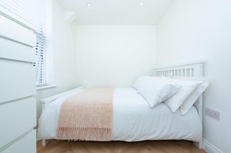 Bright, simply furnished bedroom with a white f...