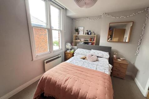 A bright and welcoming master bedroom featuring...