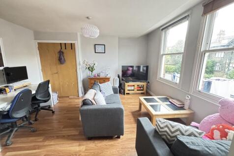 A bright and welcoming living room with large w...